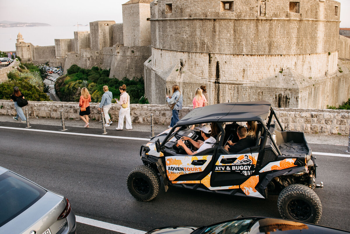 persons in buggy looking at Dubrovnik city walls up close
